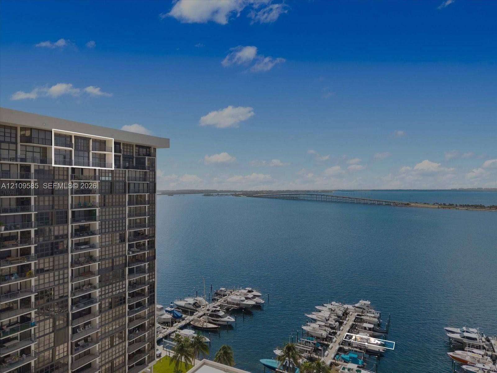 1865 Brickell Avenue, #APHVII, Miami, FL 33129 High-rise residential exterior with glass-panel balconies, featuring direct water access to a private marina and spanning water backdrop