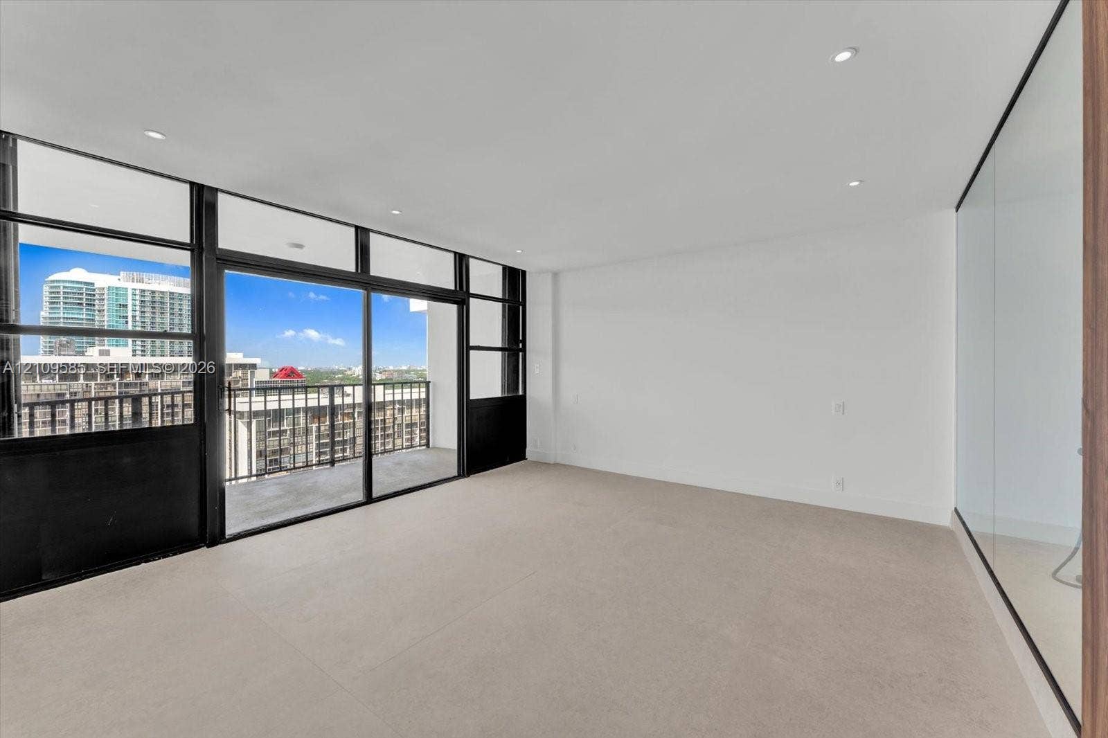 1865 Brickell Avenue, #APHVII, Miami, FL 33129 Primary view Floor-to-ceiling windows, sliding glass door access to a private balcony, recessed lighting, and neutral carpeting