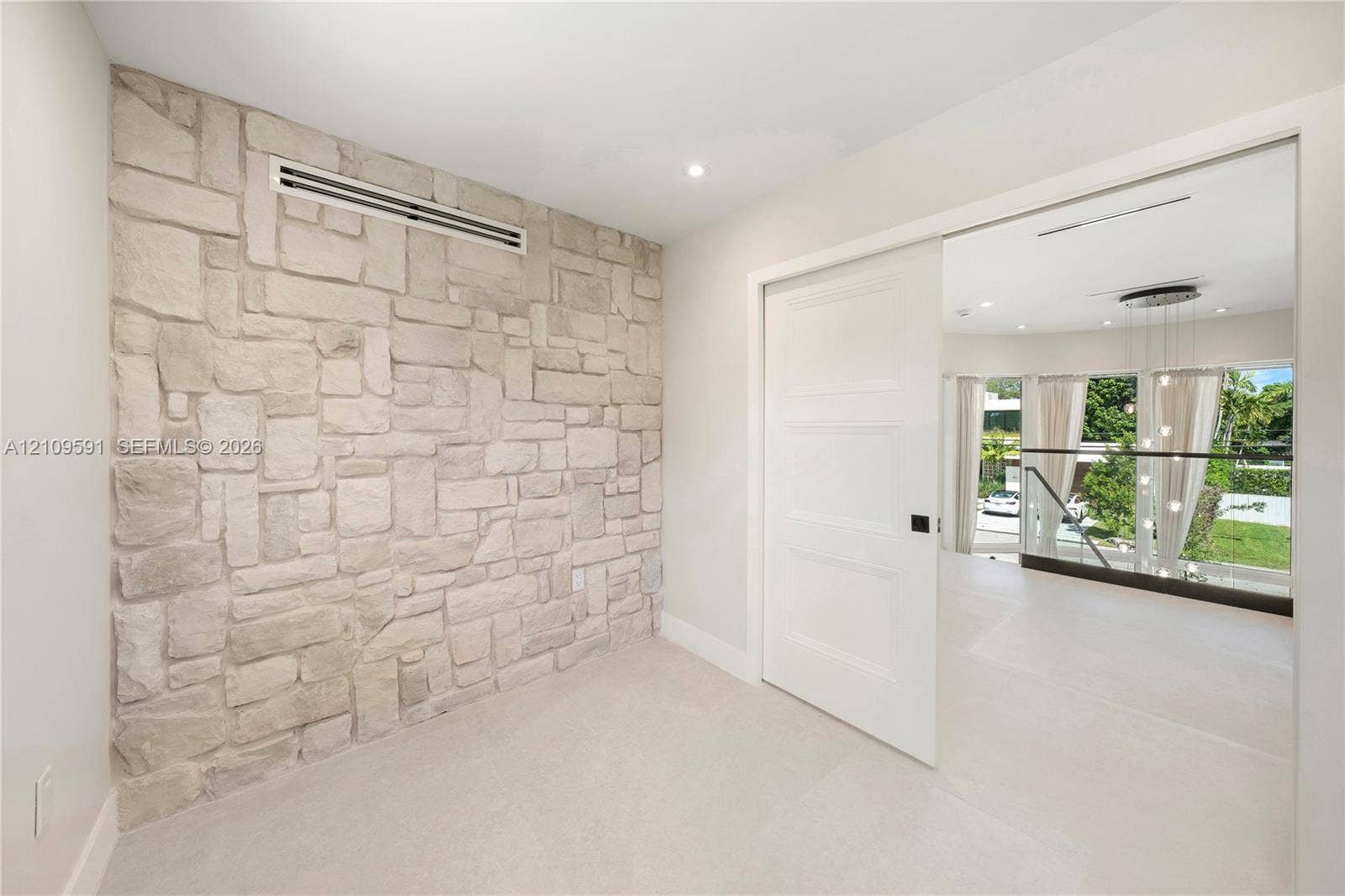 864 NE 91st Terrace, Miami Shores, FL 33138 Textured stone feature wall with recessed lighting and three-panel solid core sliding door