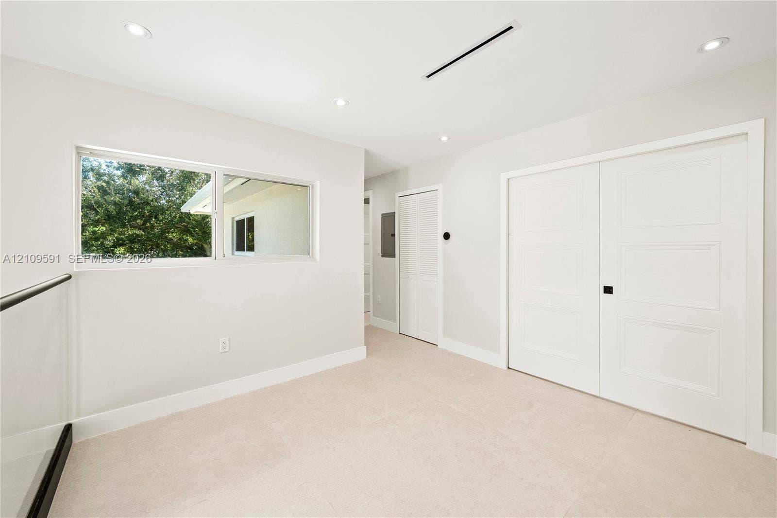 864 NE 91st Terrace, Miami Shores, FL 33138 Neutral-toned interior featuring recessed lighting, a horizontal window, wall-to-wall carpeting, and double doors with matte black hardware