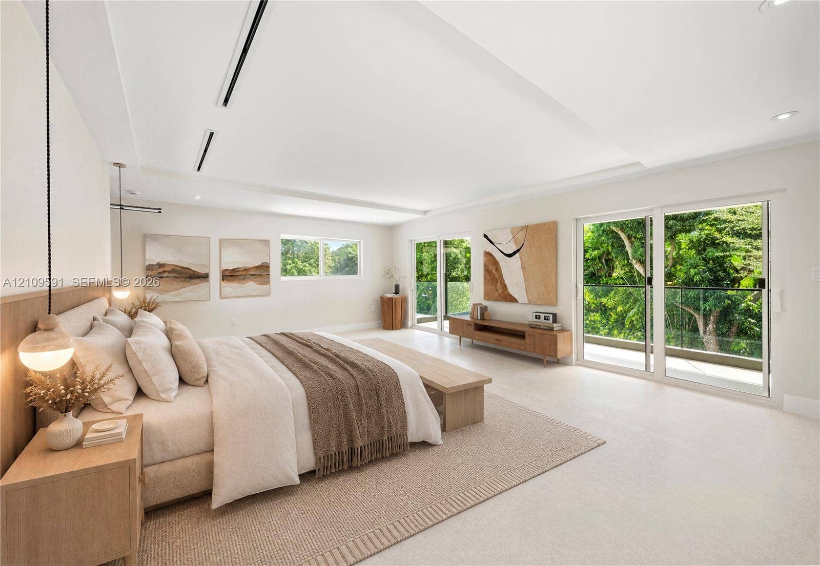 864 NE 91st Terrace, Miami Shores, FL 33138 Virtually Staged: Spacious room featuring tray ceiling, recessed lighting, dual pendant fixtures, and glass sliding doors with access to an exterior balcony