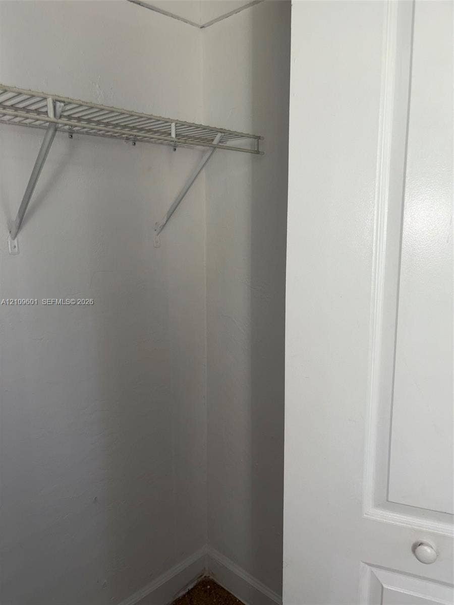 6320 Cleveland Street, Hollywood, Hollywood, FL 33024 2nd' bedroom closet featuring a white-painted door with a round knob and a built-in wire storage shelf