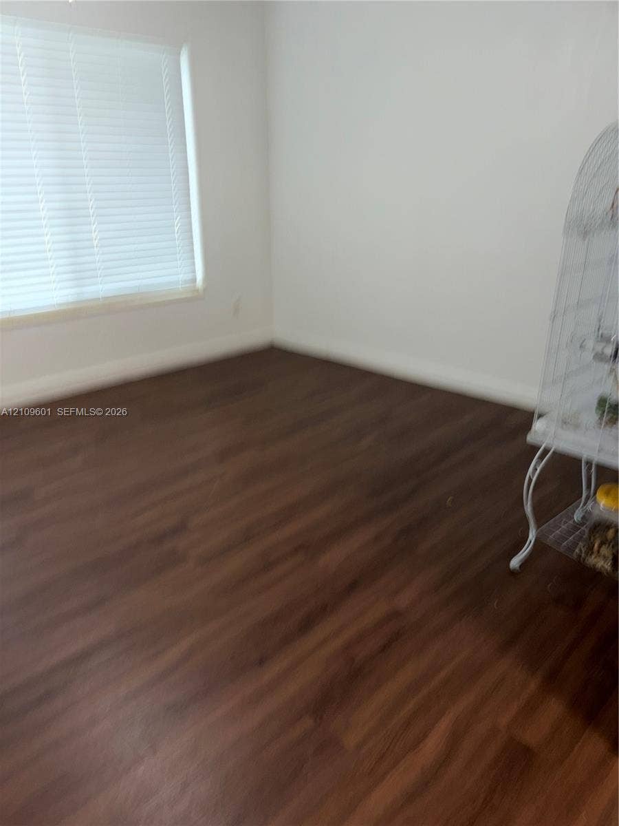 6320 Cleveland Street, Hollywood, Hollywood, FL 33024 Neutral-toned walls paired with wood-finish flooring and horizontal blind window treatments