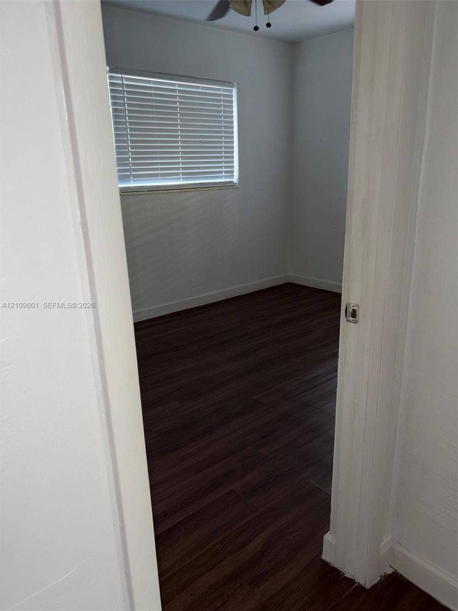 6320 Cleveland Street, Hollywood, Hollywood, FL 33024 Room featuring dark wood-finish flooring, white walls, horizontal window blinds, and a ceiling fan
