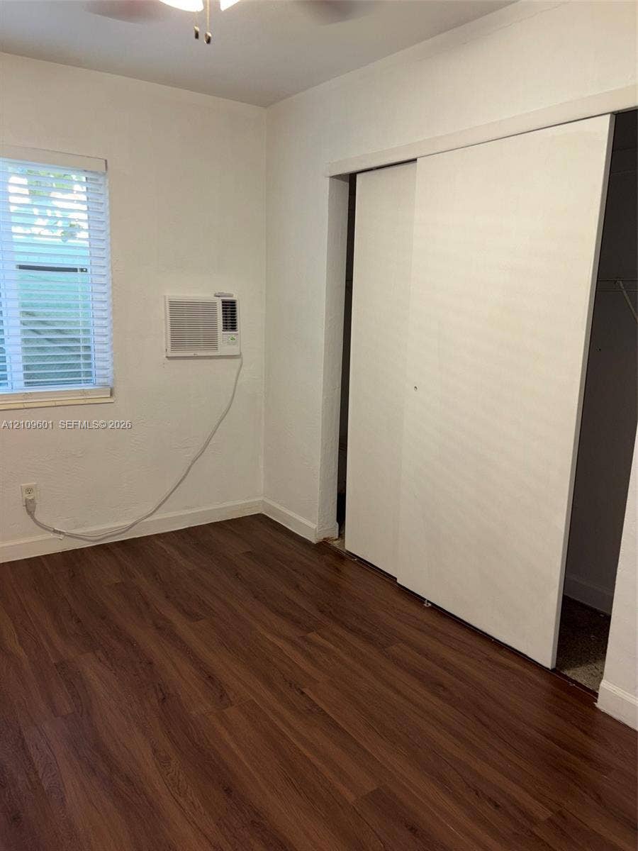 6320 Cleveland Street, Hollywood, Hollywood, FL 33024 Wood-finish flooring, sliding closet doors, wall-mounted air conditioning unit, and horizontal window blinds