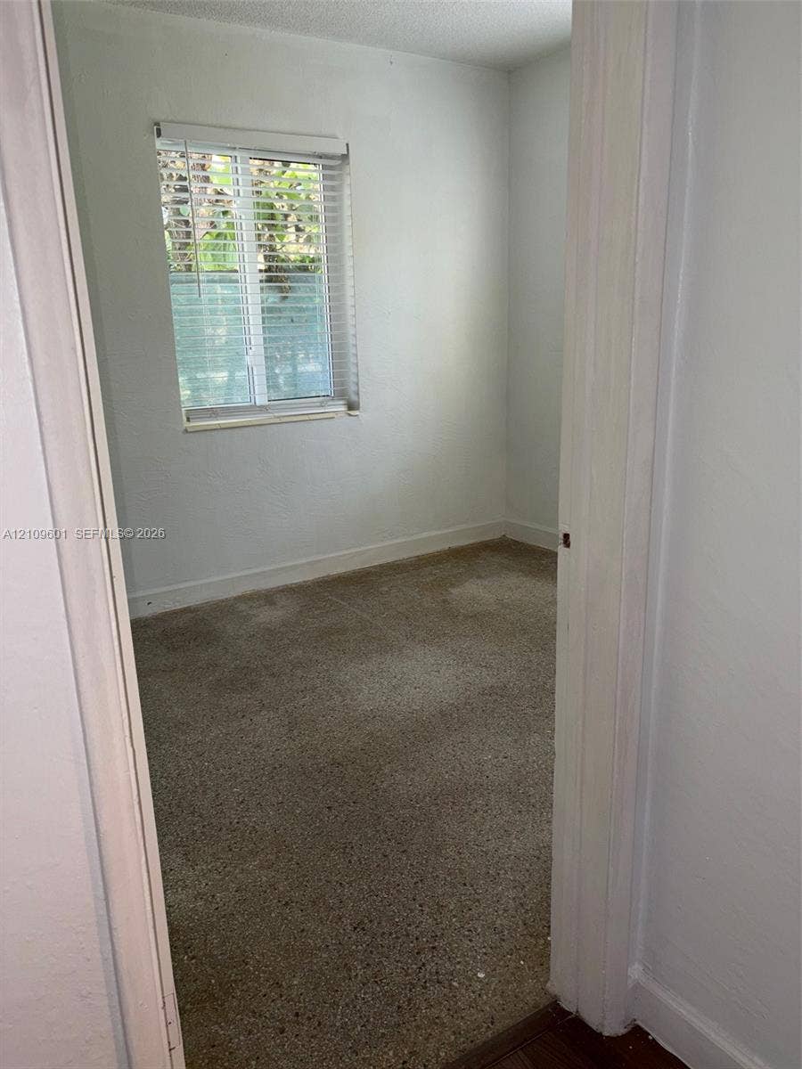 6320 Cleveland Street, Hollywood, Hollywood, FL 33024 Interior space featuring neutral wall paint, terrazzo flooring, and a single-hung window with horizontal blinds