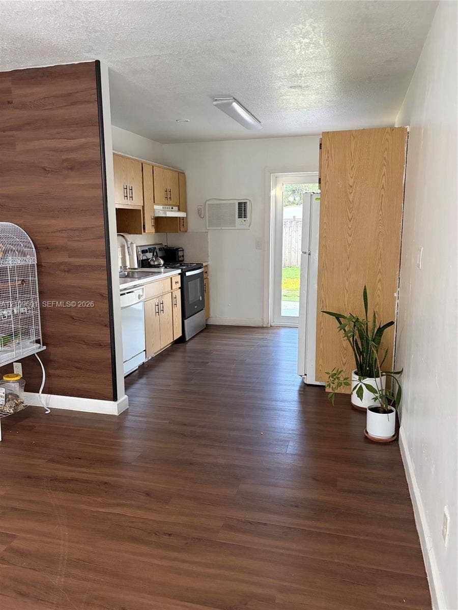 6320 Cleveland Street, Hollywood, Hollywood, FL 33024 Kitchen featuring wood-finish flooring, wood cabinetry, stainless steel appliances, and a glass-paneled exterior door