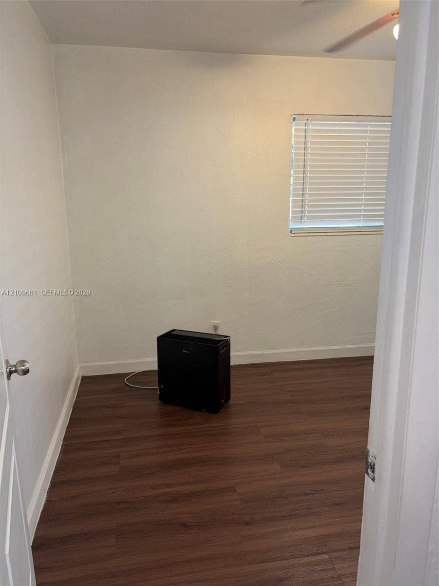 6320 Cleveland Street, Hollywood, Hollywood, FL 33024 Room featuring wood-finish flooring, smooth white walls, and a window fitted with horizontal blinds
