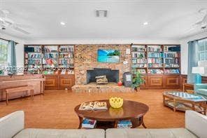 1851 NE 62nd Street, #610, Fort Lauderdale, FL 33308 Exposed brick masonry fireplace with a raised hearth, floor-to-ceiling custom built-in wooden cabinetry, and wood-finish flooring