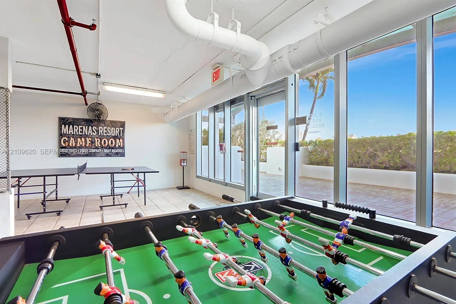 Recreational space featuring large-format ceramic floor tiles, expansive floor-to-ceiling glass windows, and direct exterior terrace access