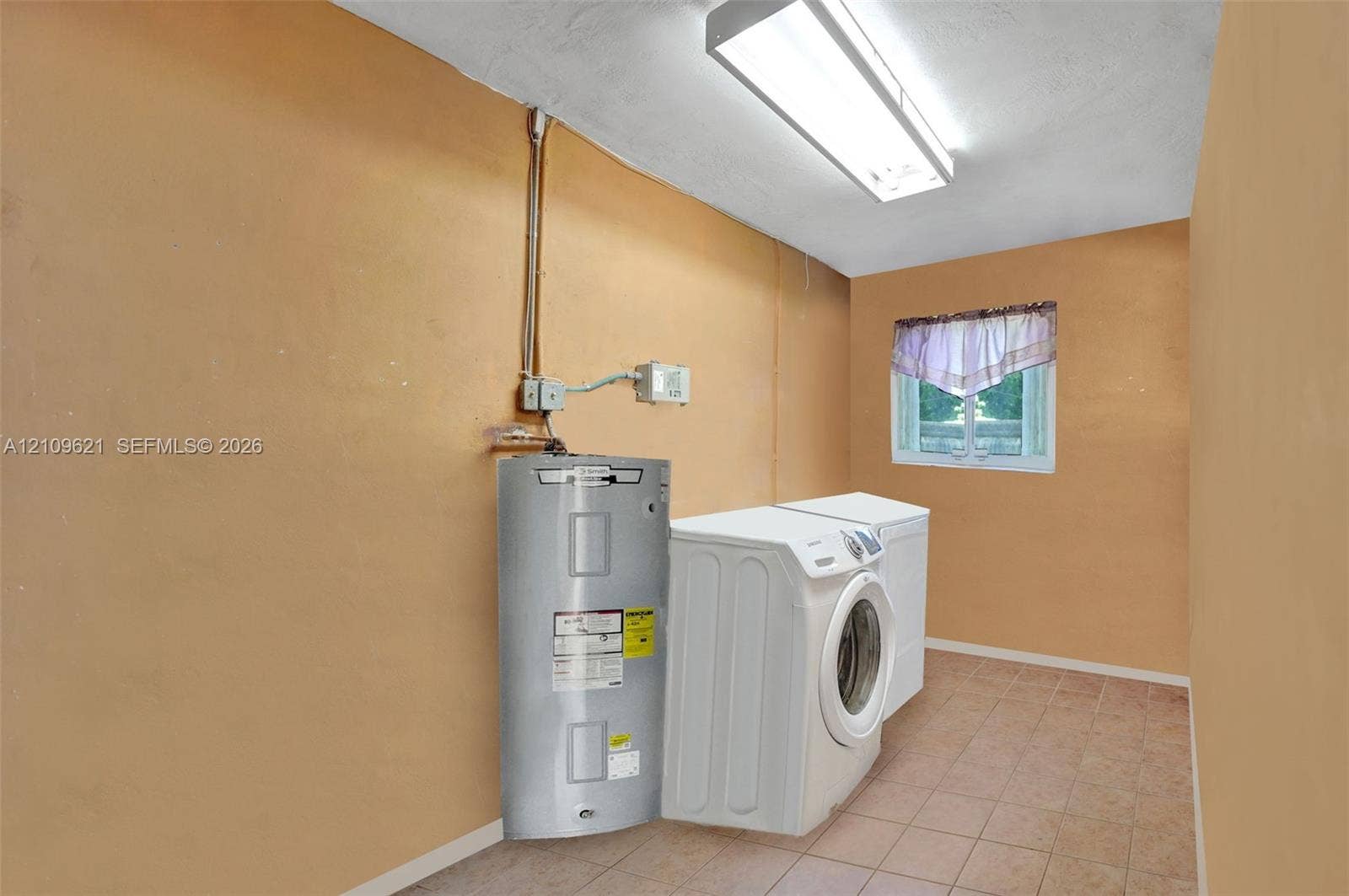 231 SW 64th Way, Pembroke Pines, FL 33023 Utility space featuring ceramic tile flooring, a mounted electric water heater, and a rectangular window