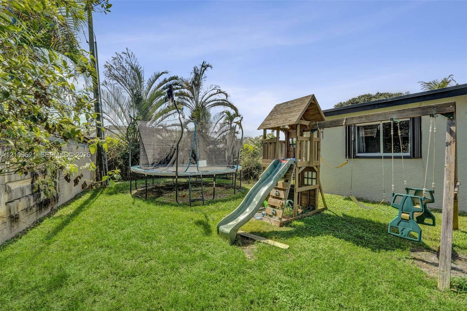 231 SW 64th Way, Pembroke Pines, FL 33023 Fenced backyard featuring a manicured lawn, masonry perimeter wall, and mature palm trees