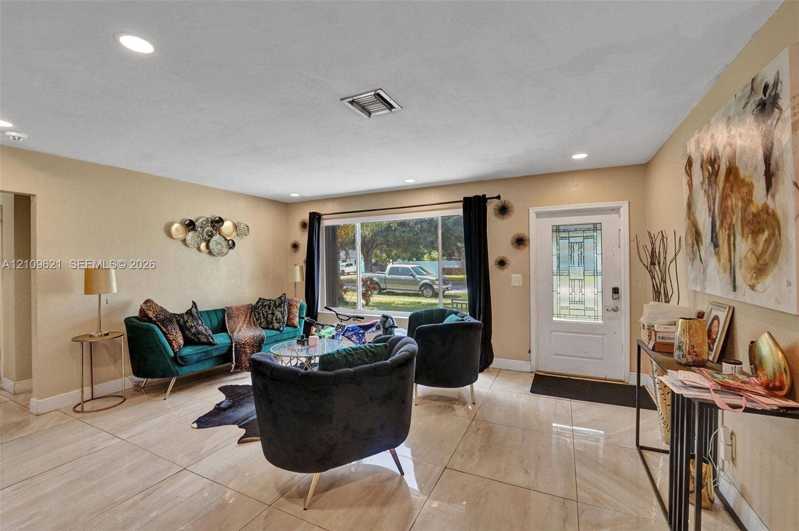 231 SW 64th Way, Pembroke Pines, FL 33023 Large-format tile flooring, recessed ceiling lighting, and an expansive window providing natural illumination, complemented by a front entry door with decorative glass paneling