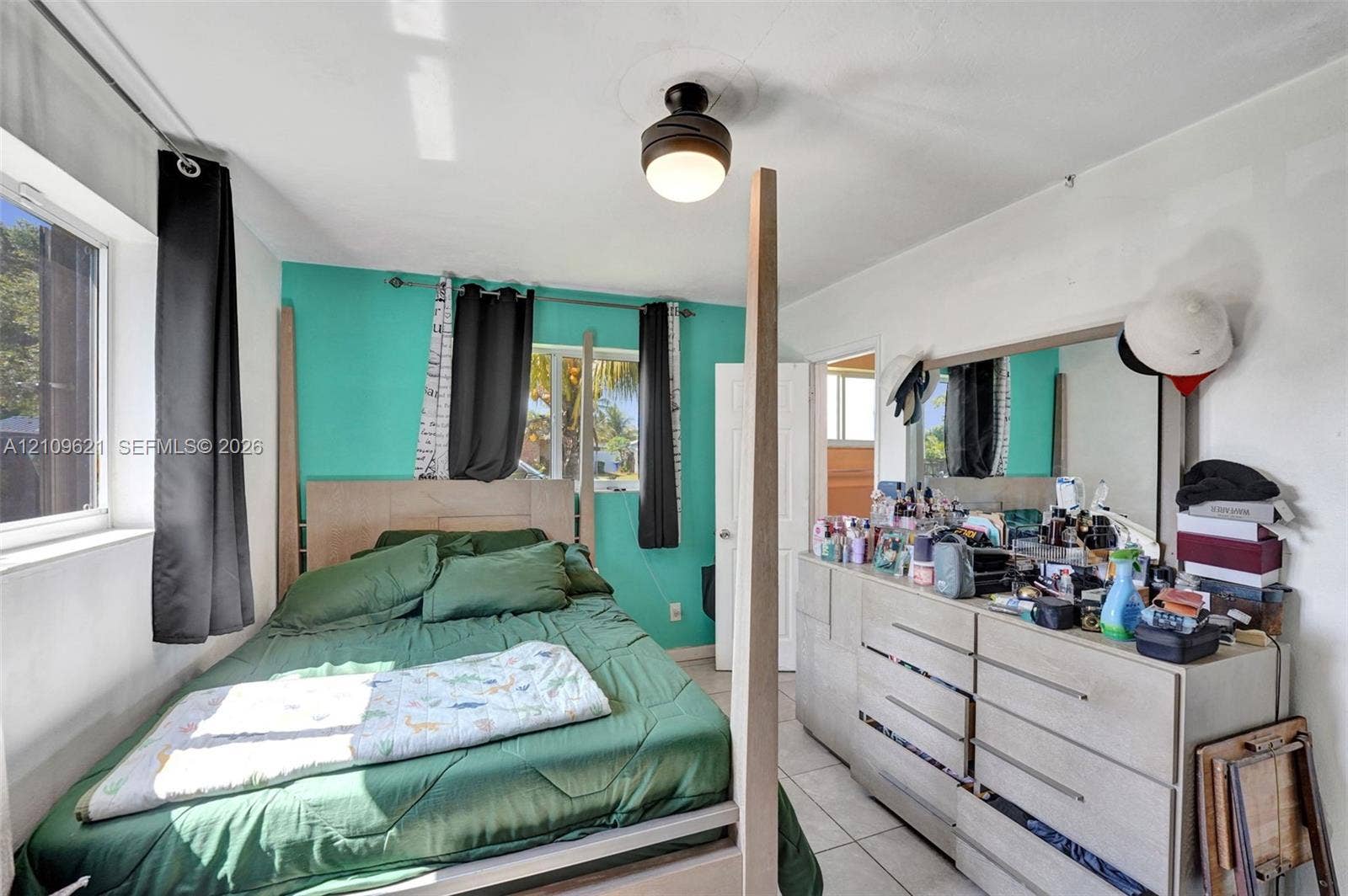 231 SW 64th Way, Pembroke Pines, FL 33023 Interior space featuring large format light-toned tile flooring, dual-aspect windows, and a central ceiling-mounted light fixture with integrated fan