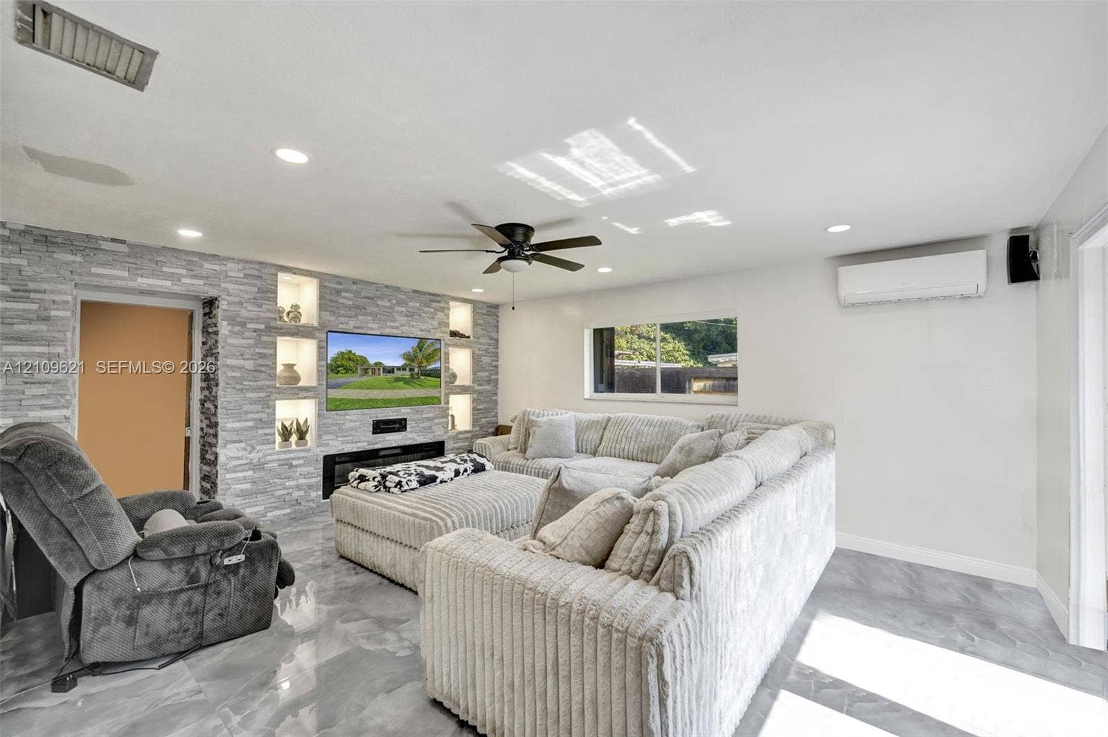 231 SW 64th Way, Pembroke Pines, FL 33023 Stacked stone accent wall with integrated shelving, built-in electric fireplace, recessed lighting, ceiling fan, and tile flooring