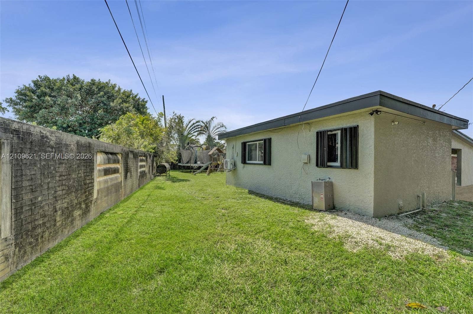 231 SW 64th Way, Pembroke Pines, FL 33023 Side yard featuring a stucco exterior, window shutters, and a masonry perimeter wall