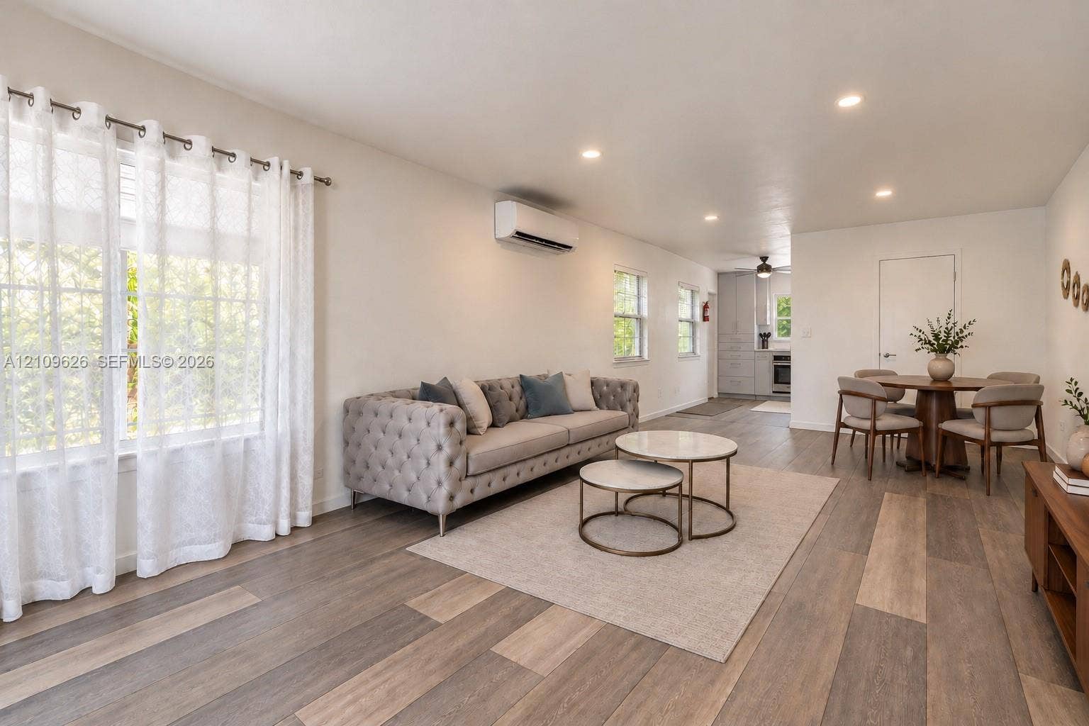 Open-concept interior featuring wood-finish flooring, recessed lighting, and a wall-mounted ductless HVAC unit