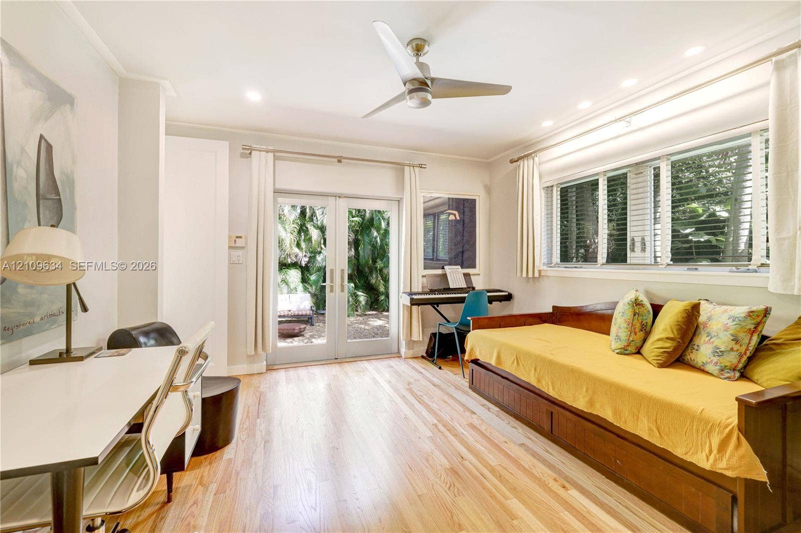 Wood-finish flooring, recessed lighting, brushed metal ceiling fan, multi-pane window with blinds, and glass-paneled french doors