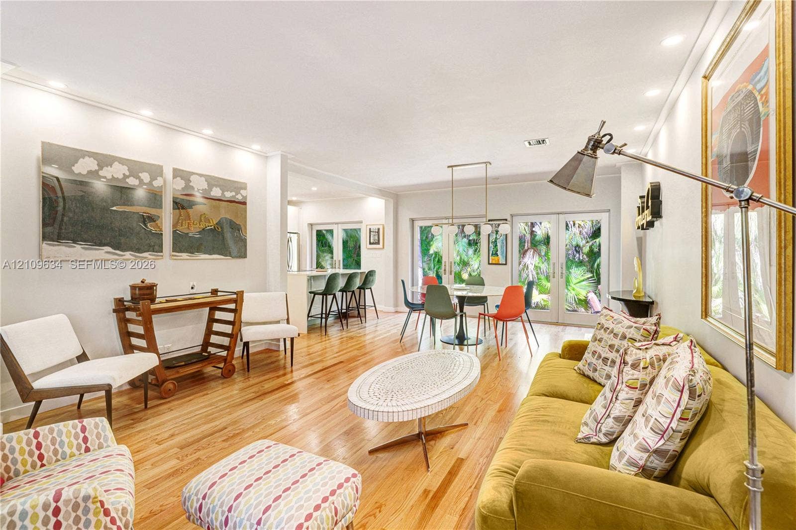 Open-concept interior featuring wood-finish flooring, recessed lighting, double French doors, and a built-in kitchen peninsula