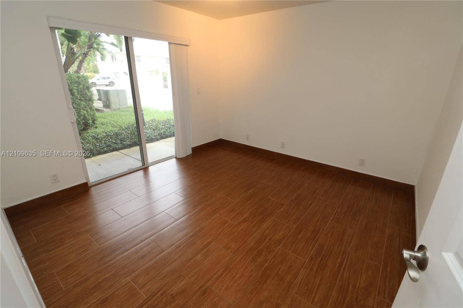 611 NE 28th Street, #1, Wilton Manors, Wilton Manors, FL 33334 Room featuring wood-finish flooring and sliding glass doors with exterior access