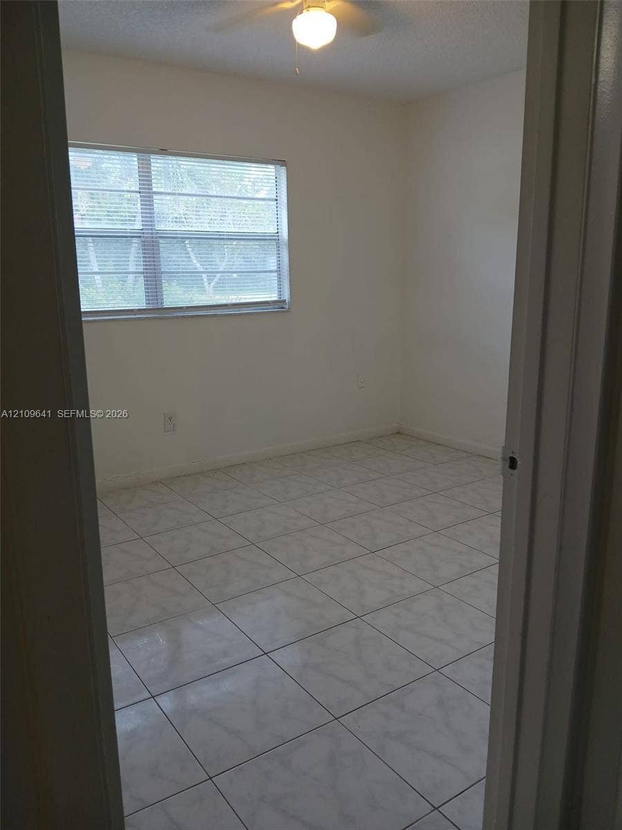 4108 NW 88th Avenue, #4, Coral Springs, Coral Springs, FL 33065 Room featuring neutral-toned ceramic tile flooring, horizontal window blinds, and a central ceiling fan with an integrated light fixture