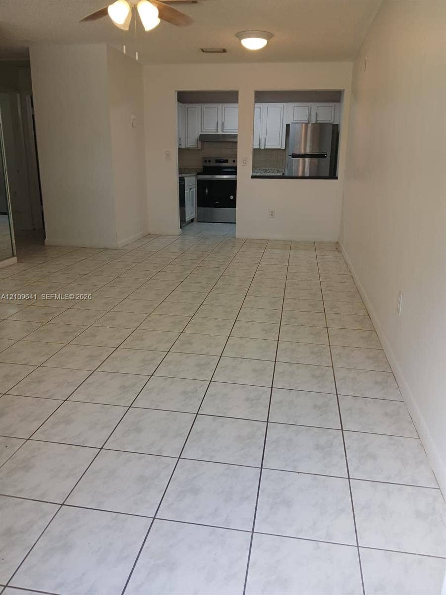 4108 NW 88th Avenue, #4, Coral Springs, Coral Springs, FL 33065 Ceramic tile flooring, white cabinetry, and stainless steel kitchen appliances, including a range and refrigerator