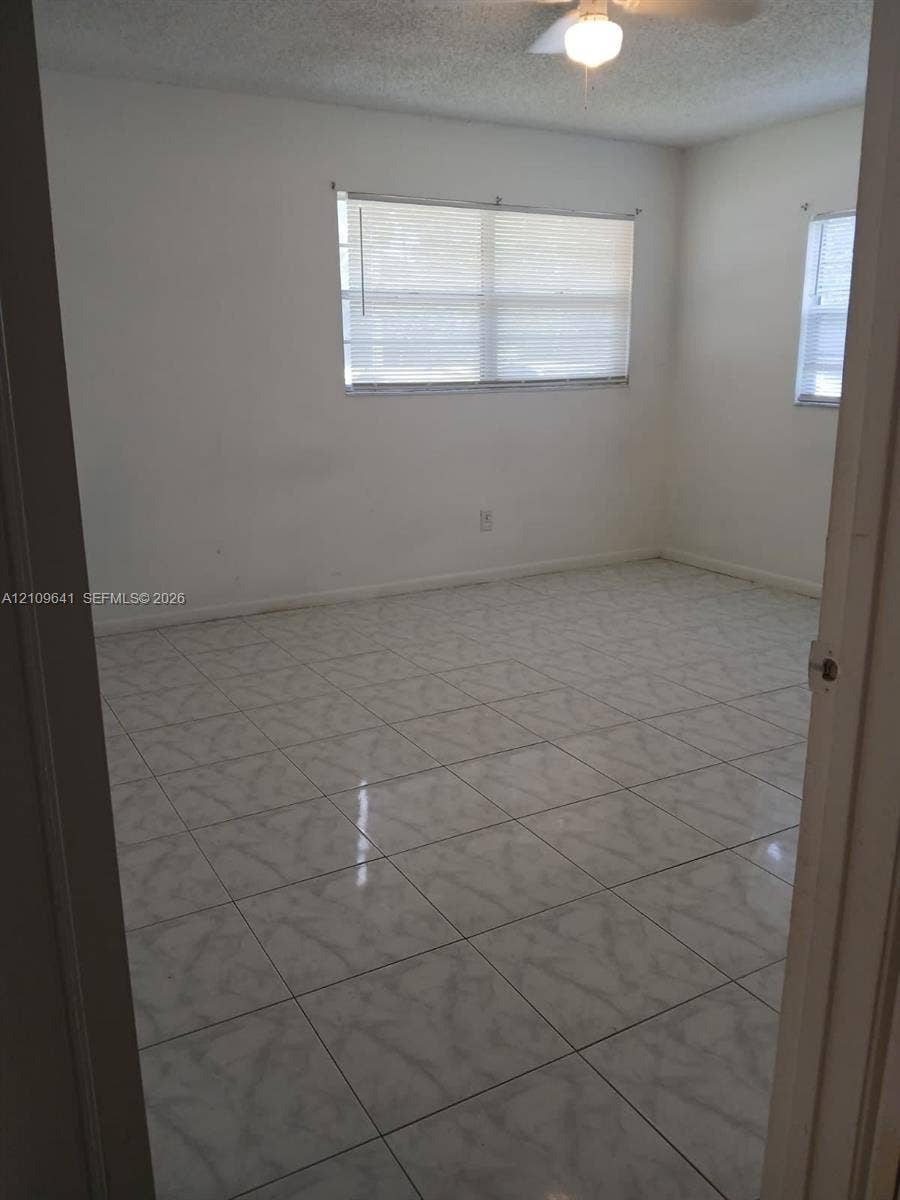 4108 NW 88th Avenue, #4, Coral Springs, Coral Springs, FL 33065 Interior room featuring neutral wall-to-wall ceramic tile flooring, dual windows, and an attached ceiling fan with light fixture