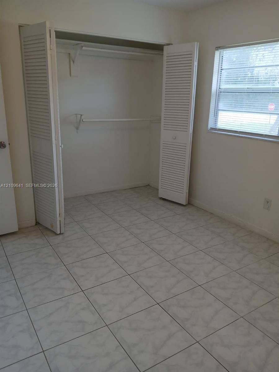 4108 NW 88th Avenue, #4, Coral Springs, Coral Springs, FL 33065 Square-tile flooring, louvered bi-fold closet doors, and single-hung window featuring horizontal blinds