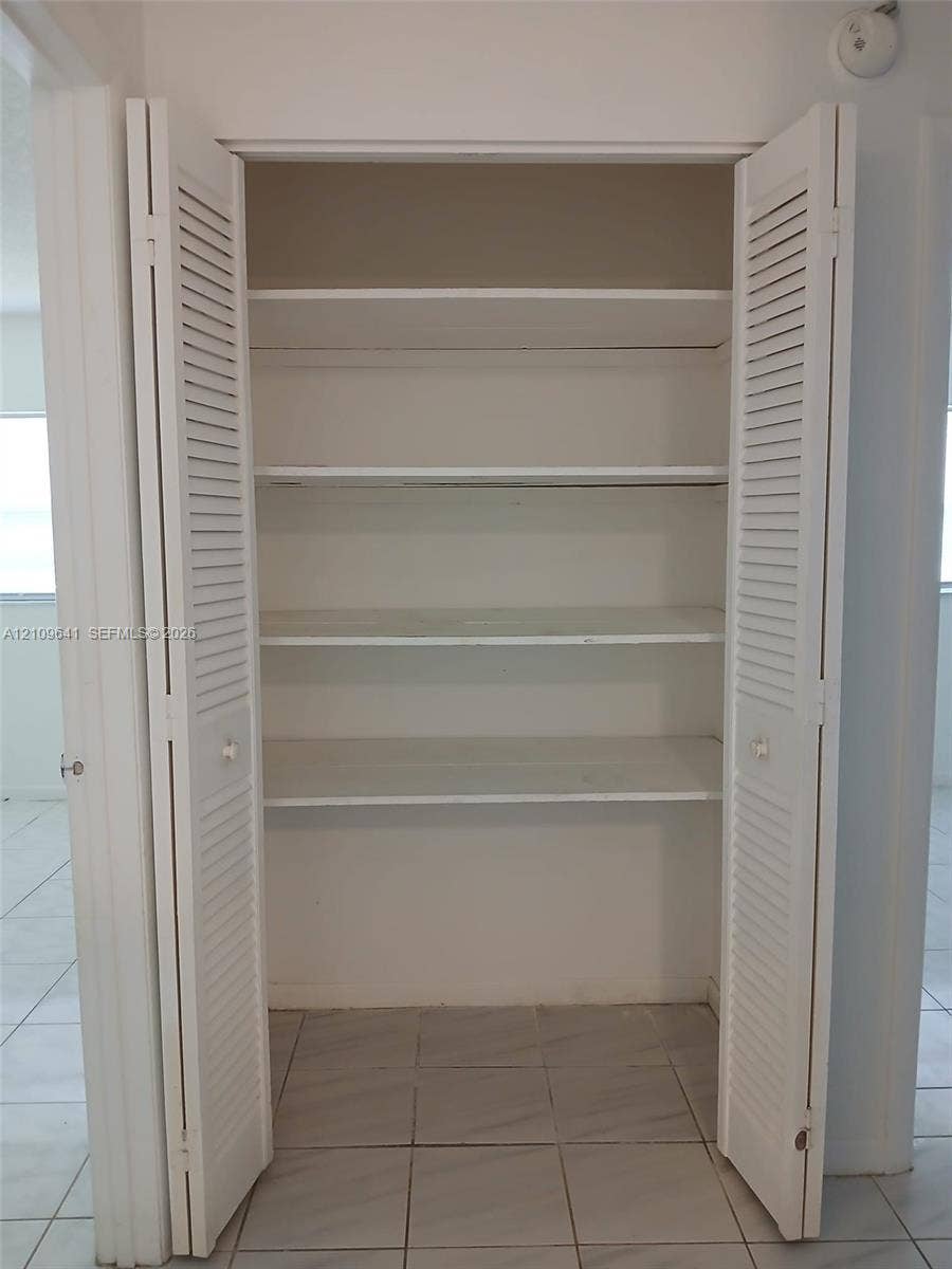 4108 NW 88th Avenue, #4, Coral Springs, Coral Springs, FL 33065 Storage closet featuring dual white louvered doors and three built-in shelves