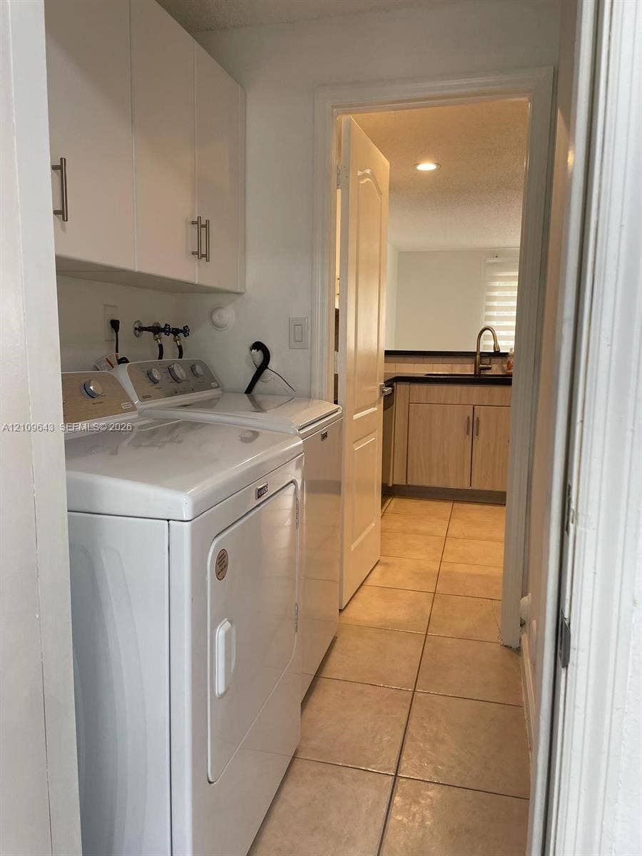 11467 NW 51st Terrace, Doral, Doral, FL 33178 Laundry area featuring white built-in cabinetry, tile flooring, and a recessed ceiling light