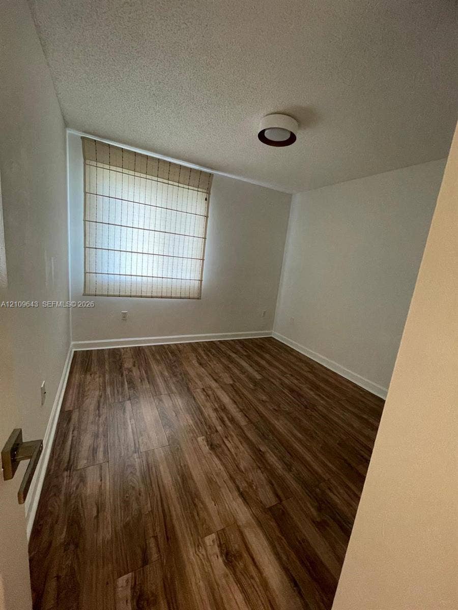 11467 NW 51st Terrace, Doral, Doral, FL 33178 Interior room featuring wood-finish flooring, a neutral color palette, and a flush-mount circular ceiling light fixture