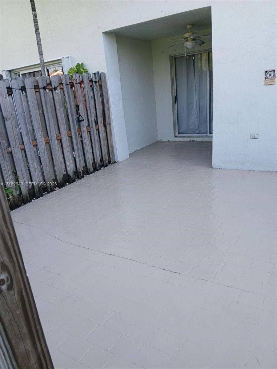 11467 NW 51st Terrace, Doral, Doral, FL 33178 Covered concrete patio featuring a ceiling fan and vertical wood privacy fencing
