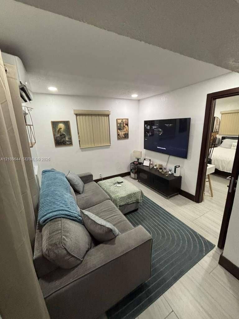1881 SW 42nd Terrace, #2, Fort Lauderdale, Fort Lauderdale, FL 33317 Neutral-toned room featuring recessed ceiling lighting, light-colored tile flooring, and a wall-mounted ductless climate control unit