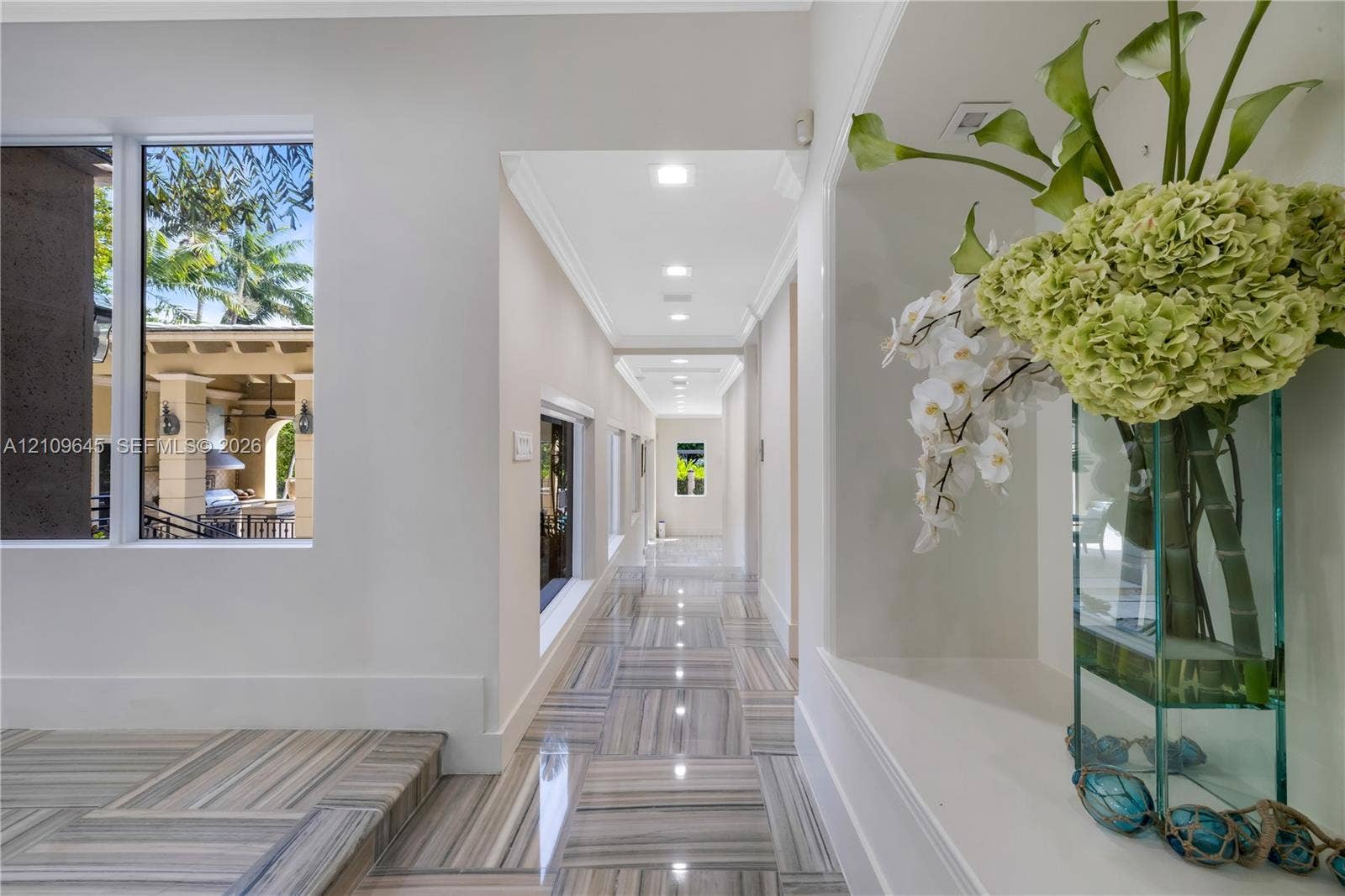 332 Costanera Road, Coral Gables, FL 33143 Hallway featuring polished stone flooring, recessed ceiling lighting, and a built-in recessed display niche