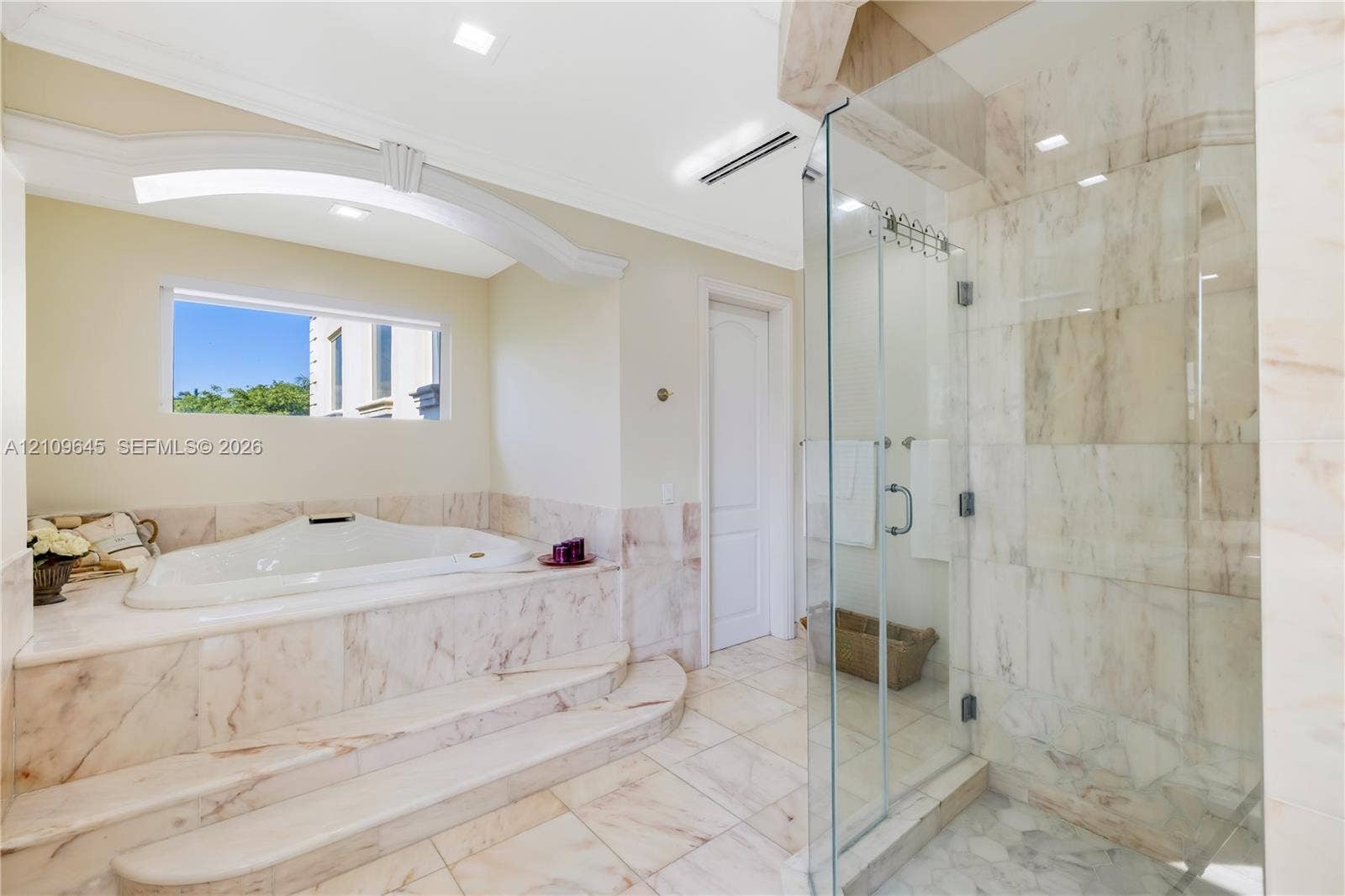 332 Costanera Road, Coral Gables, FL 33143 Jetted soaking tub with a stepped stone surround, walk-in shower with glass enclosure, stone tile flooring, and recessed ceiling lighting