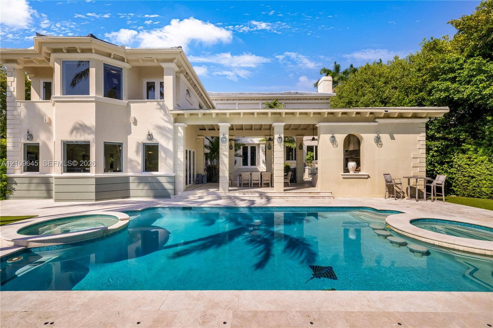 332 Costanera Road, Coral Gables, FL 33143 Stucco exterior featuring a covered patio, swimming pool with integrated spa, and stone-finished pool decking