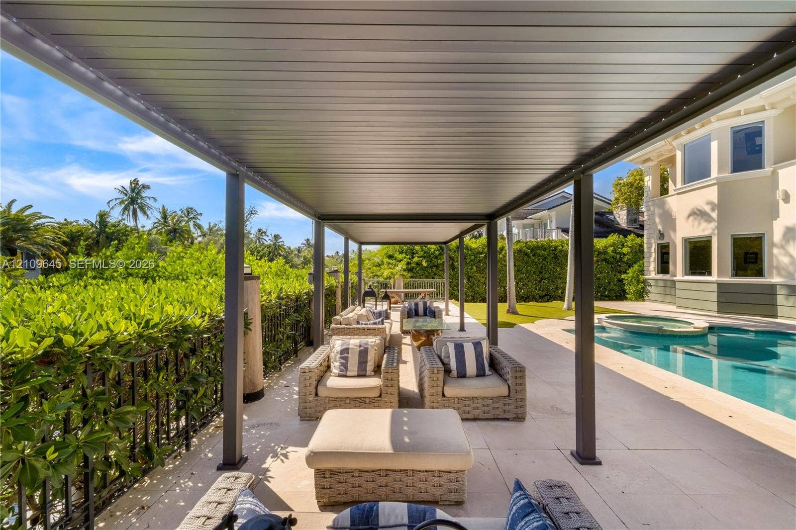 332 Costanera Road, Coral Gables, FL 33143 Covered outdoor patio featuring a metal pergola, large-format tile flooring, in-ground pool, and a metal perimeter fence