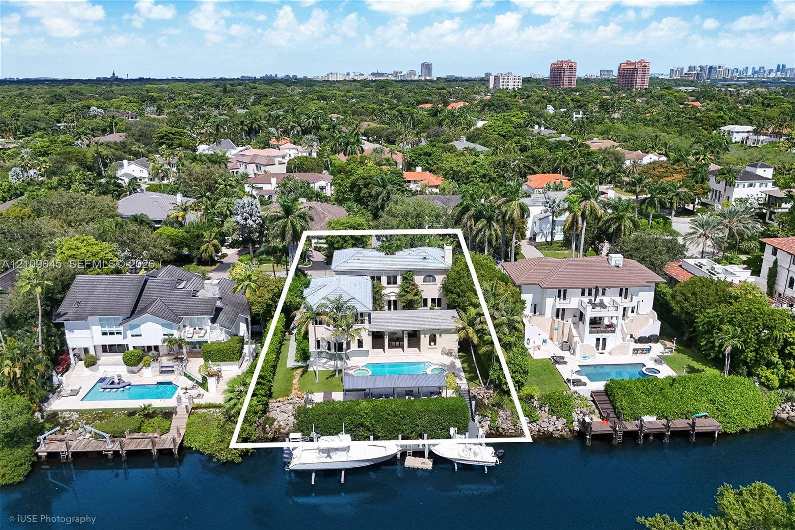 332 Costanera Road, Coral Gables, FL 33143 Waterfront property featuring a multi-story residence, private swimming pool, integrated spa, and a bulkhead-lined dock on a canal