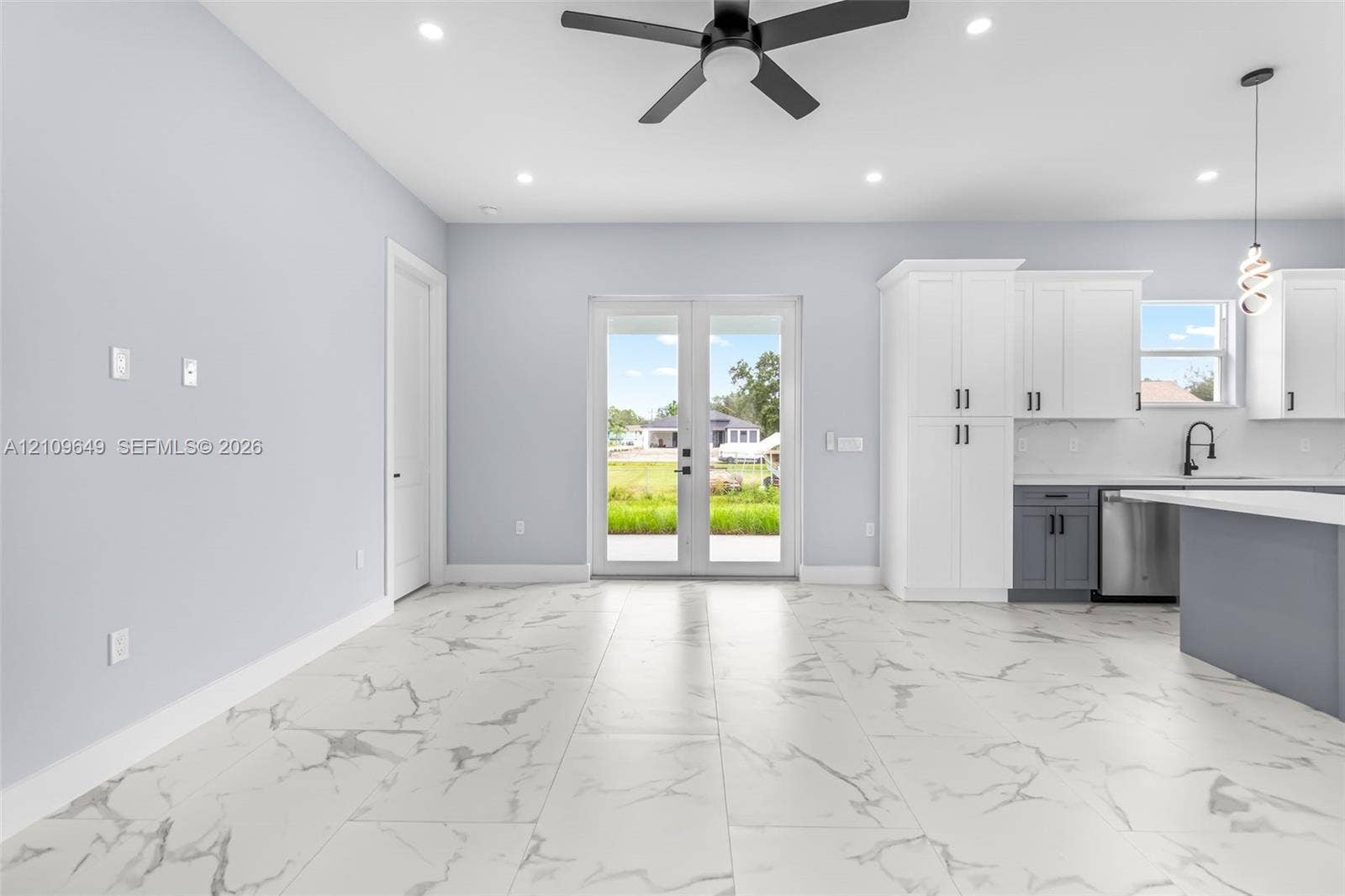 2818 42nd St Sw Lehigh Acres, Lehigh Acres, FL 33976 Large-format tile flooring, dual-tone cabinetry, stainless steel appliances, matte black hardware, and double glass-paneled exterior doors