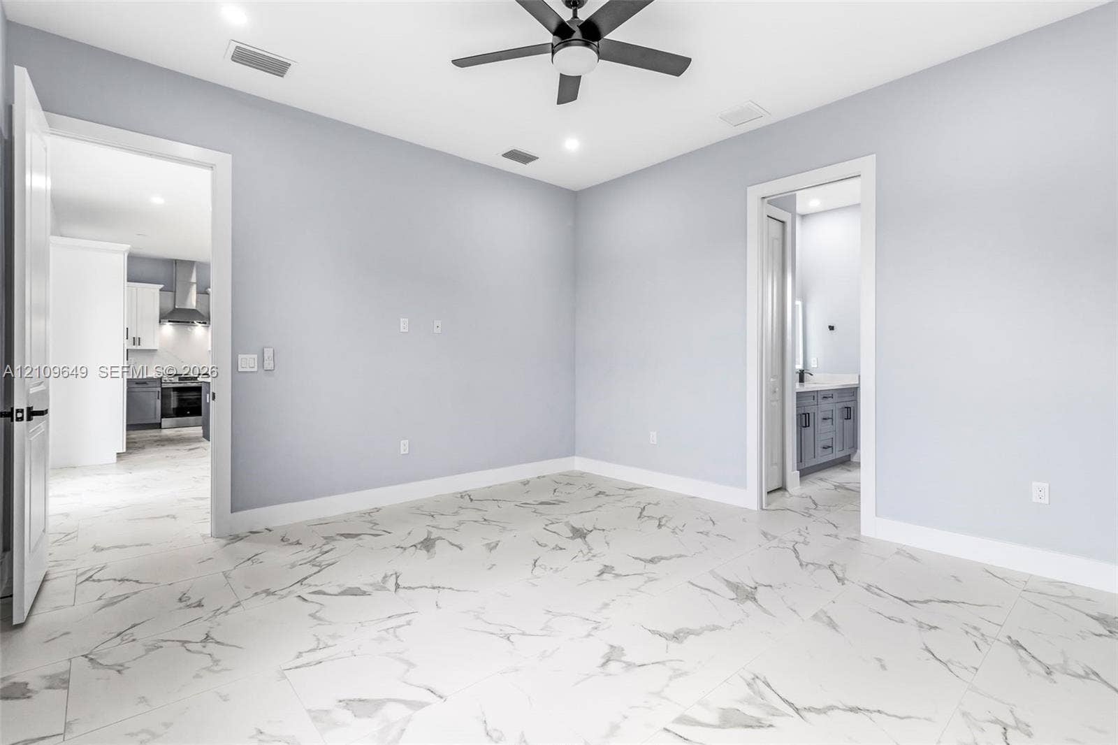 2818 42nd St Sw Lehigh Acres, Lehigh Acres, FL 33976 Room featuring large-format tile flooring with a veined pattern, recessed ceiling lighting, and a dark-finish ceiling fan
