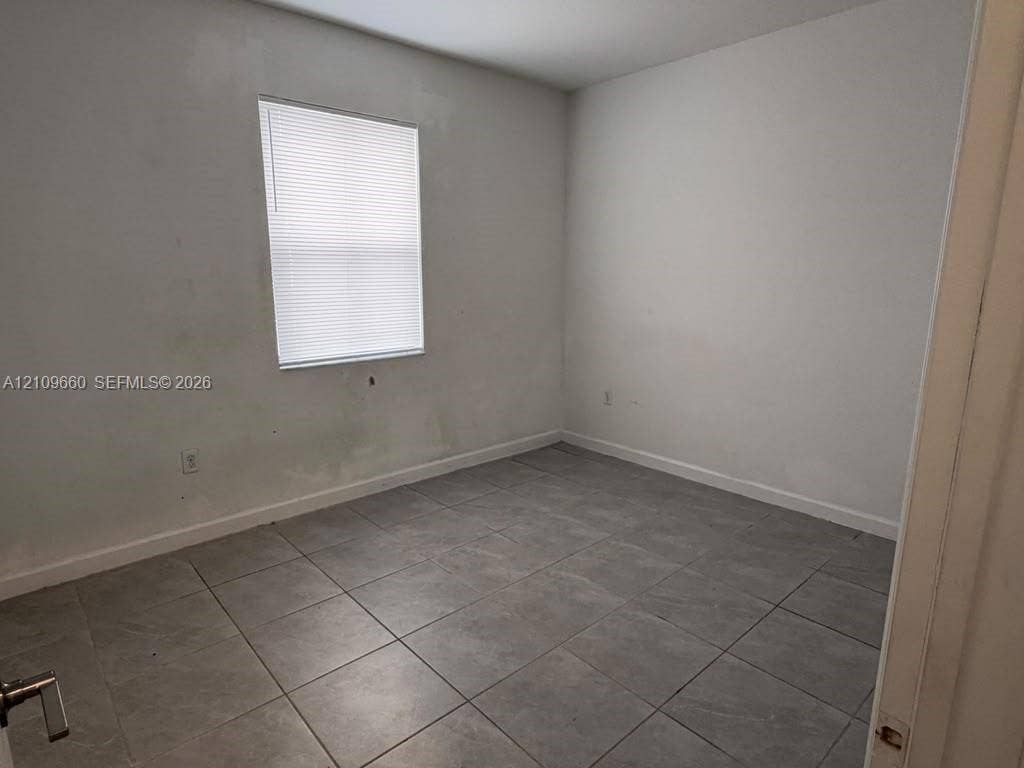 23275 SW 133 Rd Avenue, #2, Homestead, Homestead, FL 33032 Neutral-toned tile flooring and a single-pane window with installed blinds