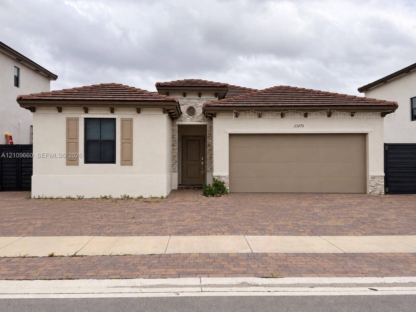 23275 SW 133 Rd Avenue, #2, Homestead, Homestead, FL 33032 Single-story stucco exterior featuring a tile roof, stone masonry accents, exposed rafters, and a paved driveway