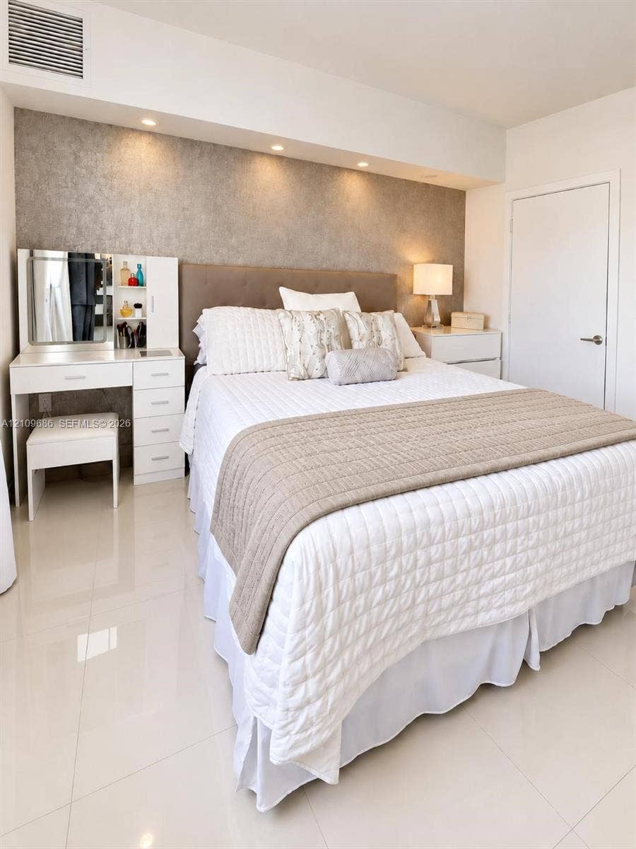 Textured stone-finish accent wall with recessed overhead lighting and polished tile flooring