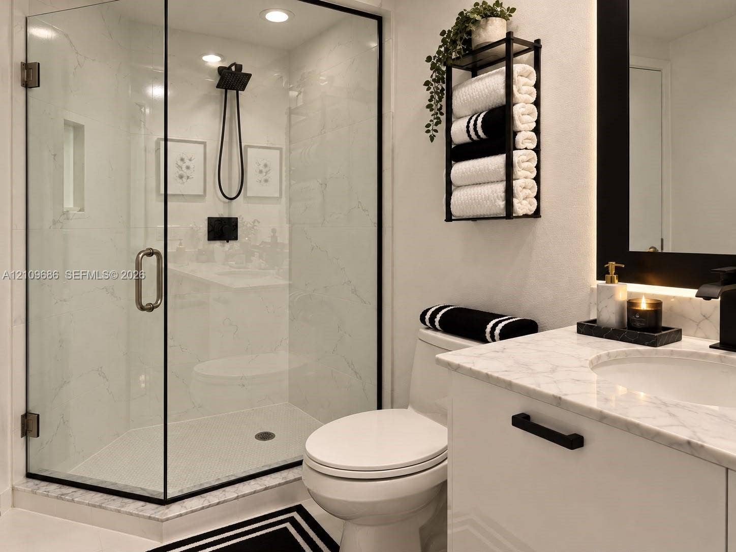 Walk-in shower with black-trimmed glass enclosure, stone-finish wall tile, and black rainfall showerhead