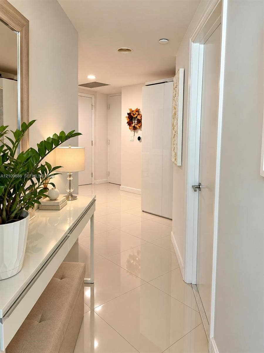 Polished tile flooring, neutral wall finishes, and multiple interior door access points