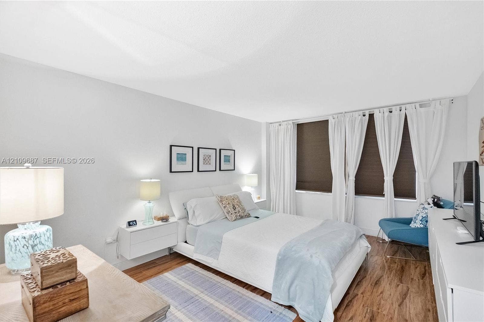 5555 Collins Avenue, #5C, Miami Beach, FL 33140 Wood-finish flooring, neutral wall tones, and large windows with integrated blinds