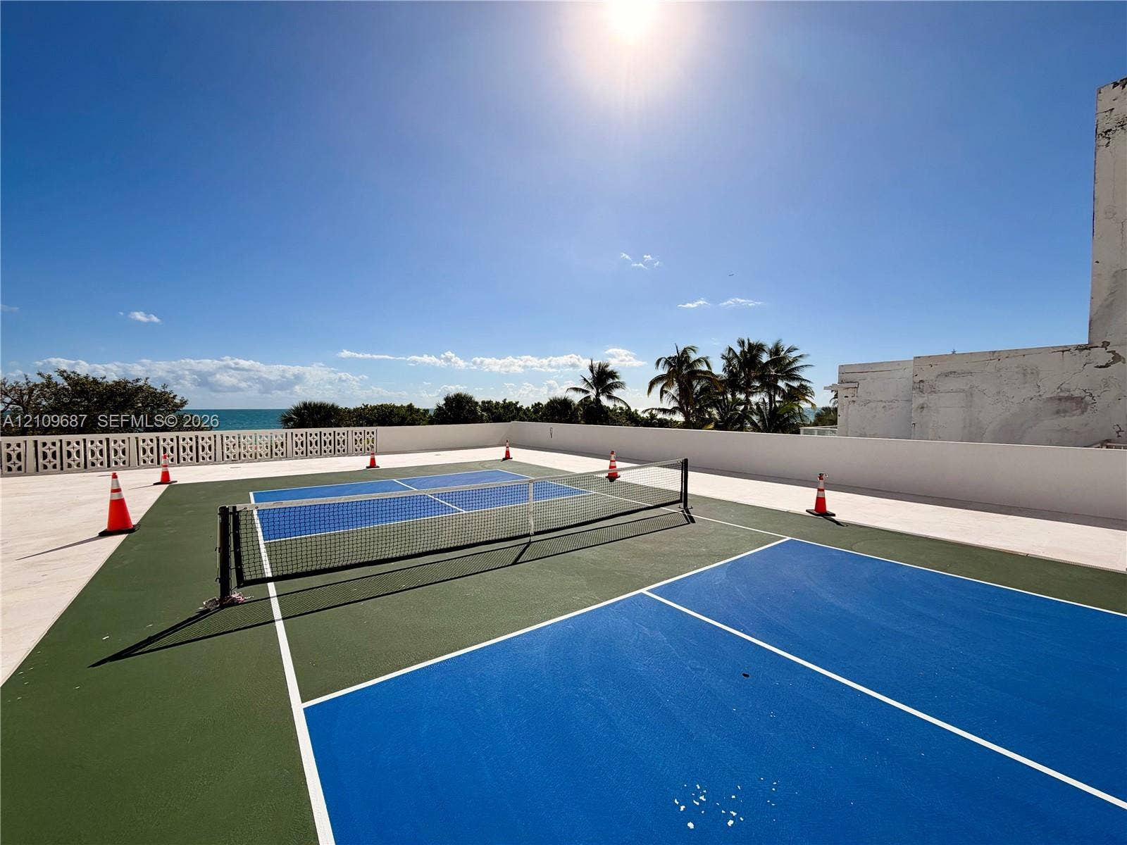 5555 Collins Avenue, #5C, Miami Beach, FL 33140 Rooftop sports court featuring a multi-color surface, net system, and decorative concrete screen wall