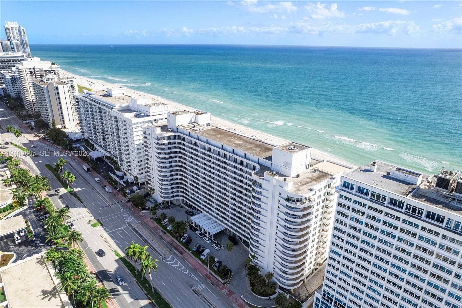 5555 Collins Avenue, #5C, Miami Beach, FL 33140 High-rise residential structure featuring multi-level balconies, expansive oceanfront positioning, and immediate proximity to the coastline