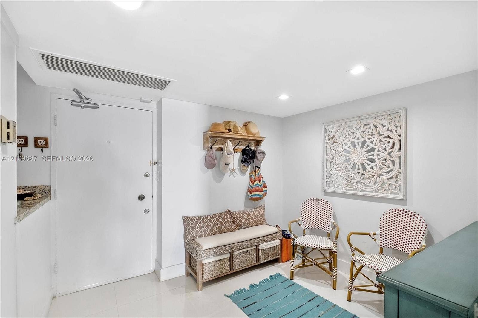 5555 Collins Avenue, #5C, Miami Beach, FL 33140 Entryway featuring recessed ceiling lighting, neutral tile flooring, and a wall-mounted wooden coat rack