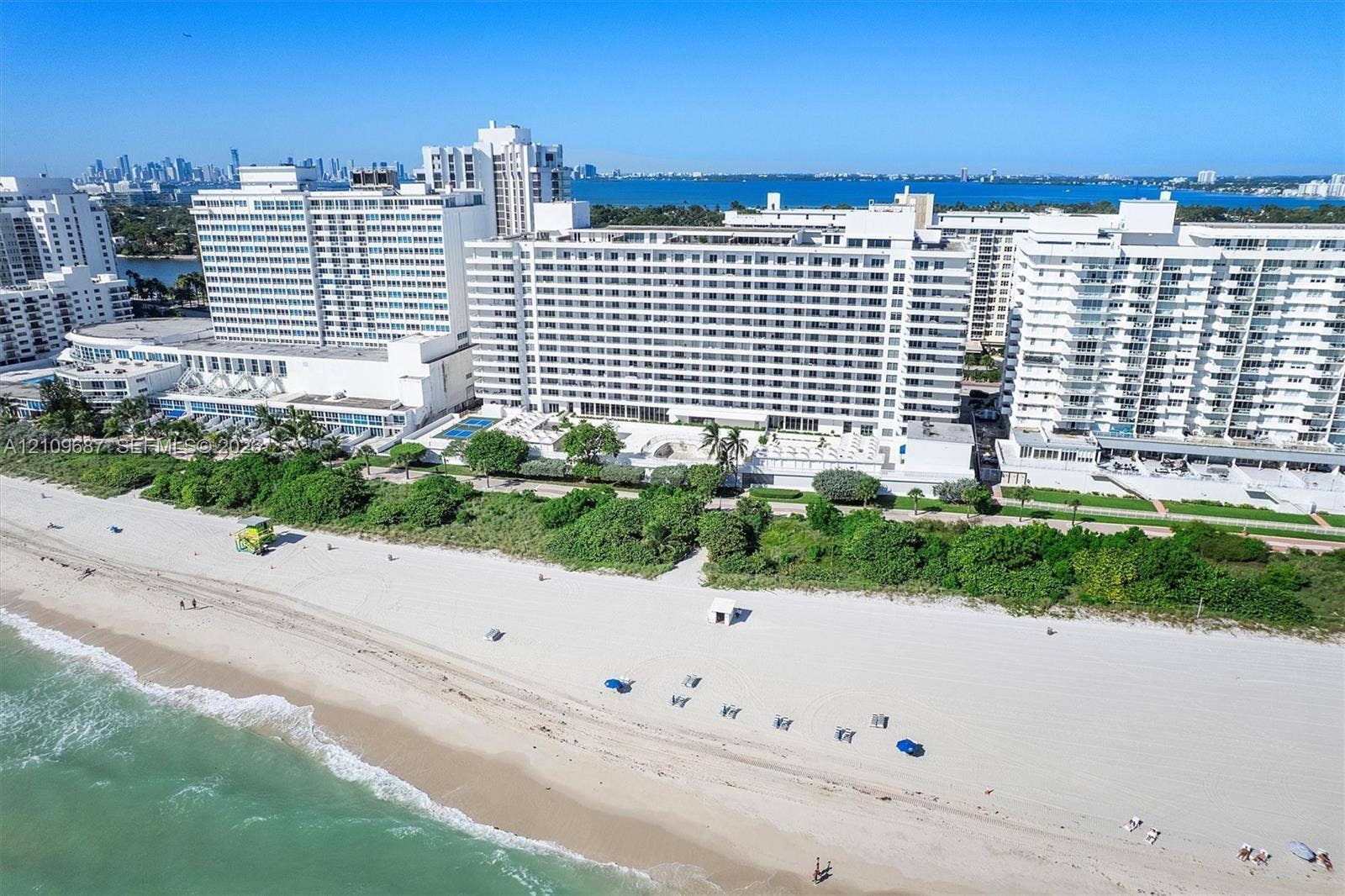5555 Collins Avenue, #5C, Miami Beach, FL 33140 Oceanfront high-rise building with direct beach access, coastal landscaping, and exterior balconies